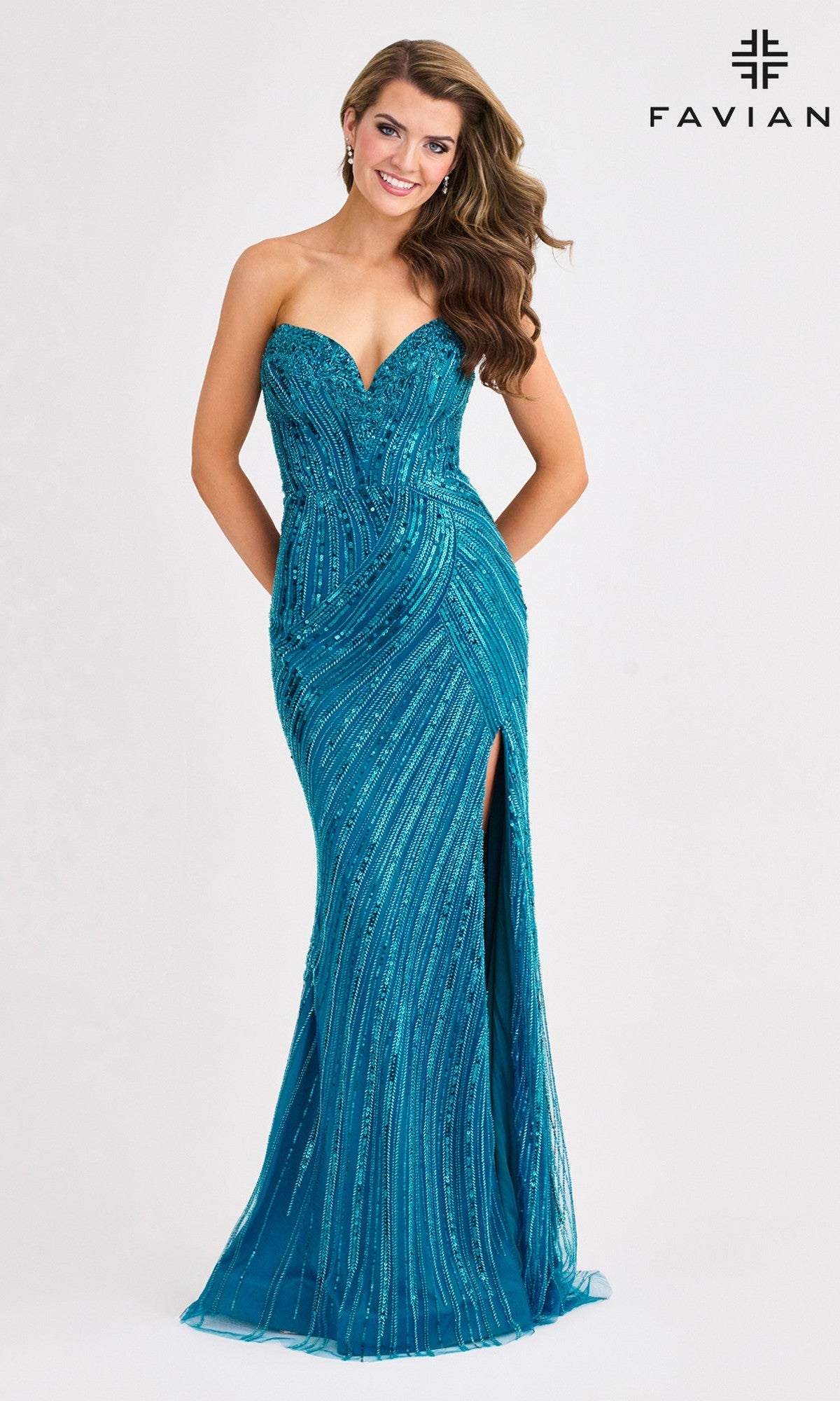 A woman poses in the Strapless Long Blue Sequin Prom Dress: Faviana 11411, featuring a sweetheart neckline and thigh-high slit, against a white background. The Faviana logo is displayed in the top right corner.